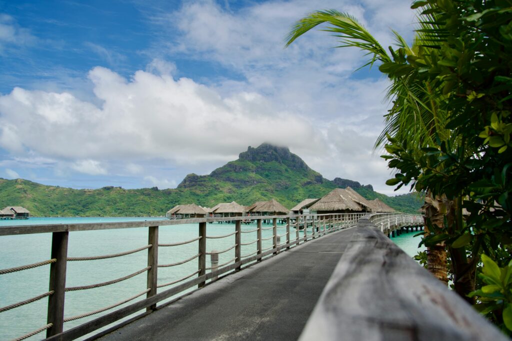 Lunes de miel d'exception : destinations pour un voyage inoubliable Stunning view of overwater bungalows with a mountain backdrop in Bora Bora, French Polynesia.
