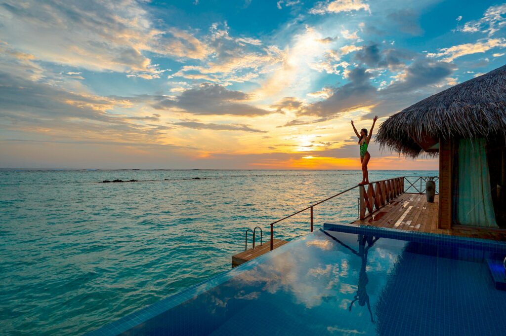 Woman enjoying a stunning sunset at a luxury Maldives resort